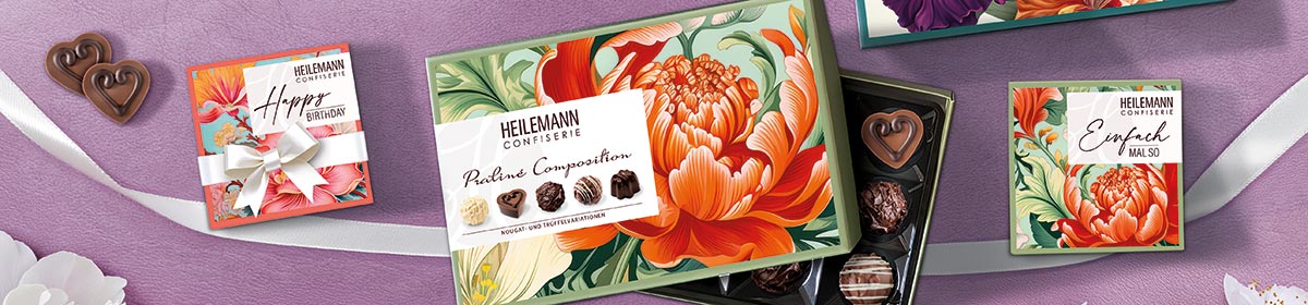 Pralinen mit floralen Verpackungen als Muttertagsgeschenk auf violettem Hintergrund