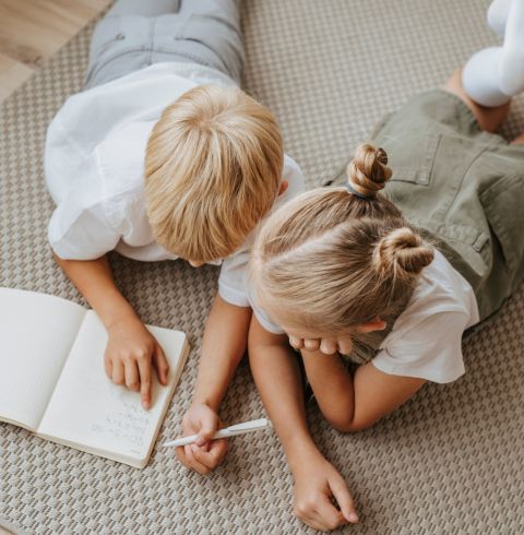 Kinder liegen und schreiben HEILEMANN